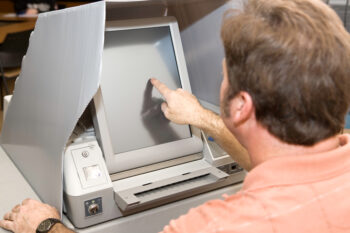 Man voting on a new touch screen machine in Florida.